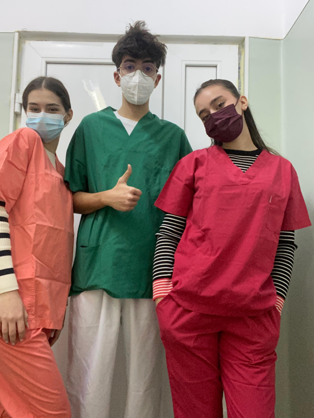 Drei DSA-Jugendliche in medizinischer Arbeitskleidung und mit Schutzmasken beim Betriebspraktikum